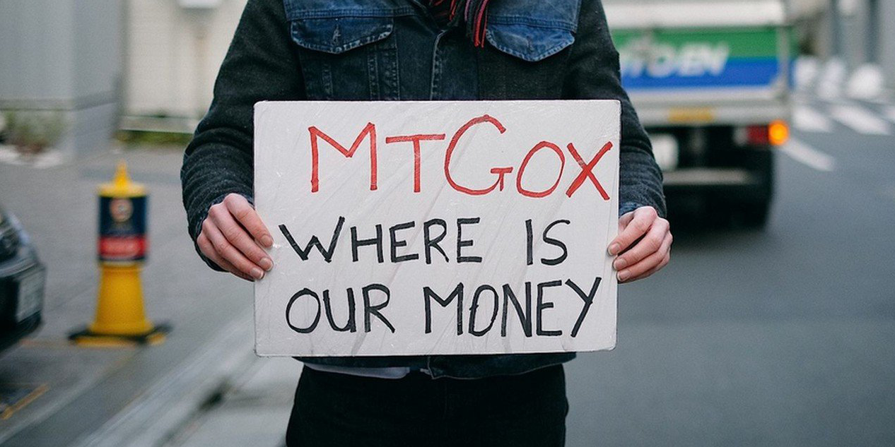 Man holding a sign that reads "MTGOX WHERE IS OUR MONEY"